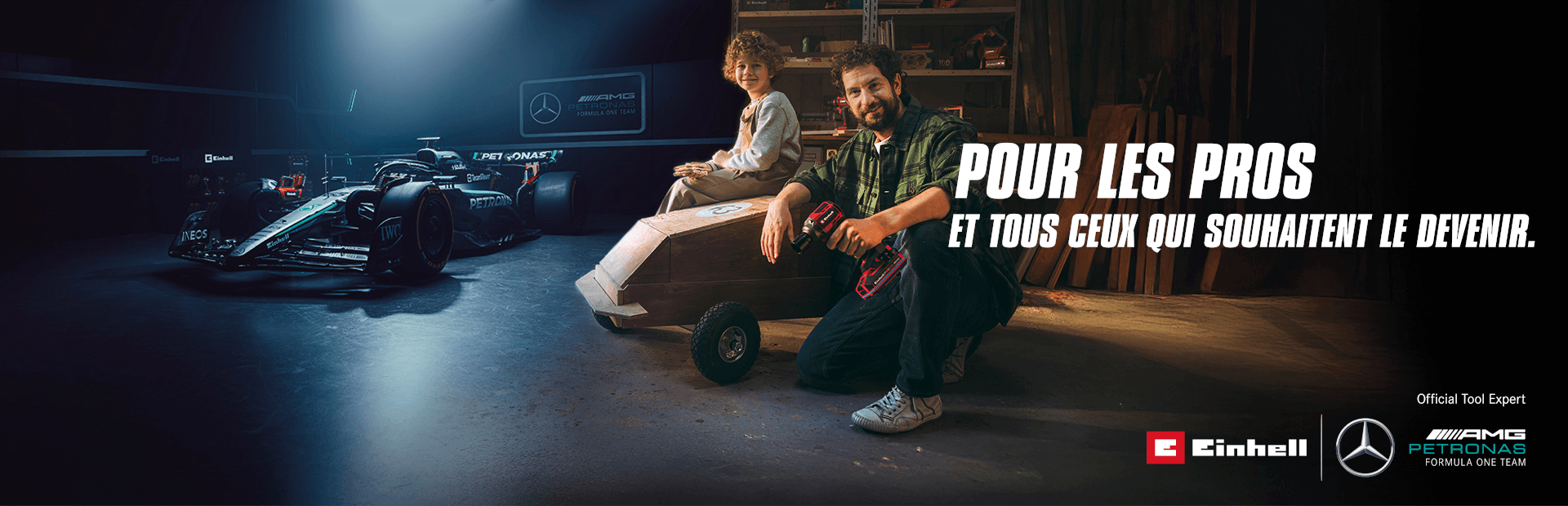 Un père et un enfant dans un atelier avec une caisse à savon faite maison. En arrière-plan, une voiture de Formule 1 Mercedes-AMG PETRONAS et des outils Einhell. À droite, il est écrit : « Pour les professionnels et ceux qui veulent le devenir. »