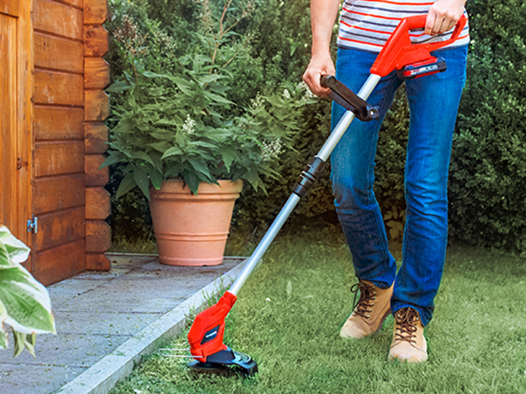 A man working with a Einhell lawntrimmer 