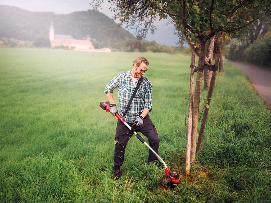 A man working with a Einhell lawntrimmer 