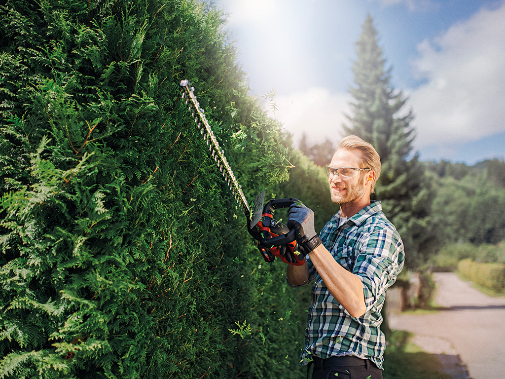 A man working with a hedge trimmer