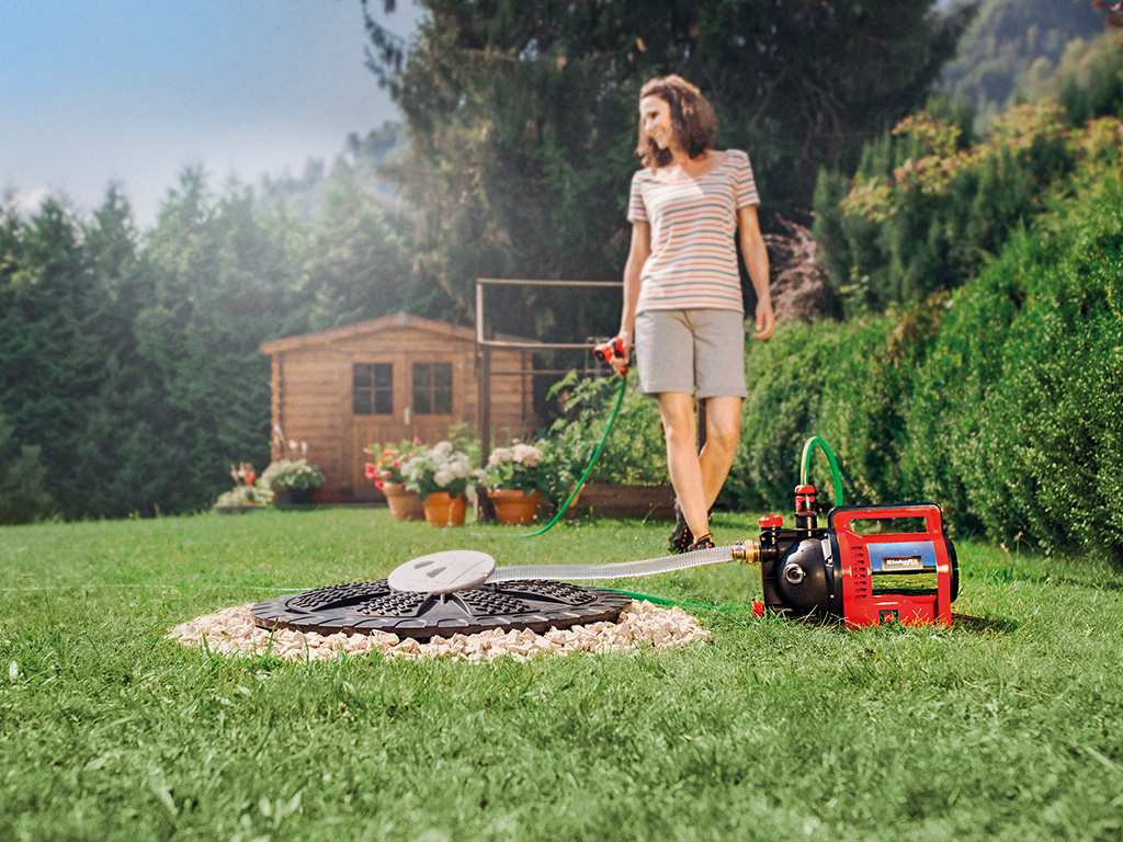 A woman is working with her cordless garden pump