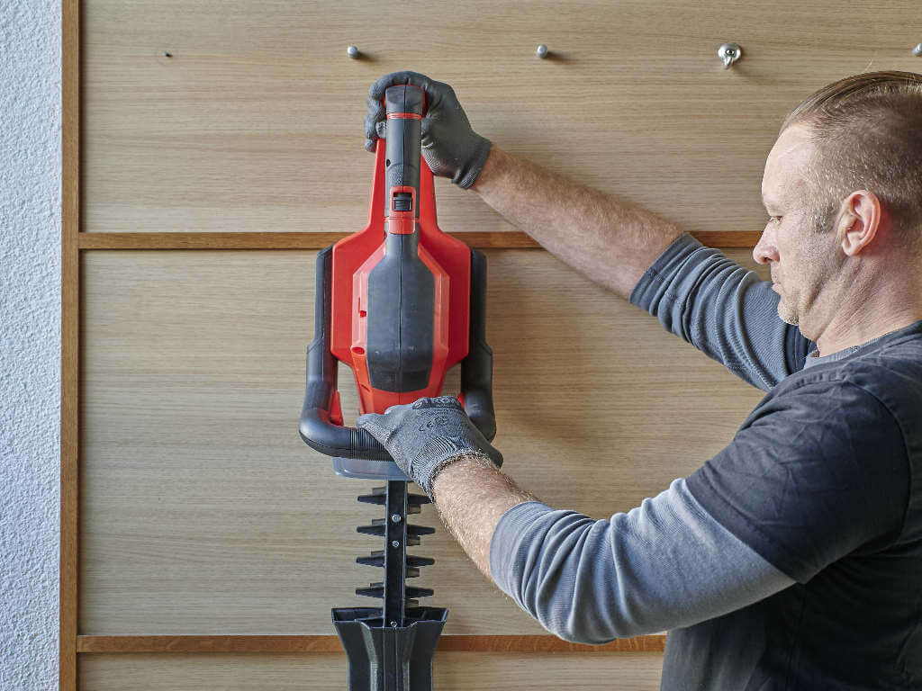 A man hanging an Einhell tool up.