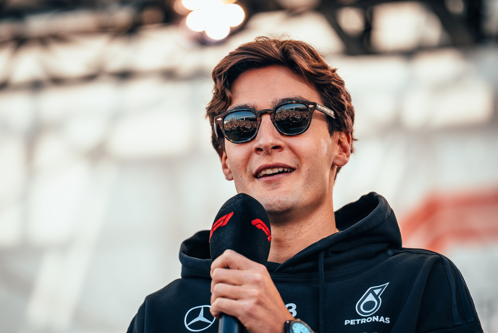 George Russell speaking into a microphone