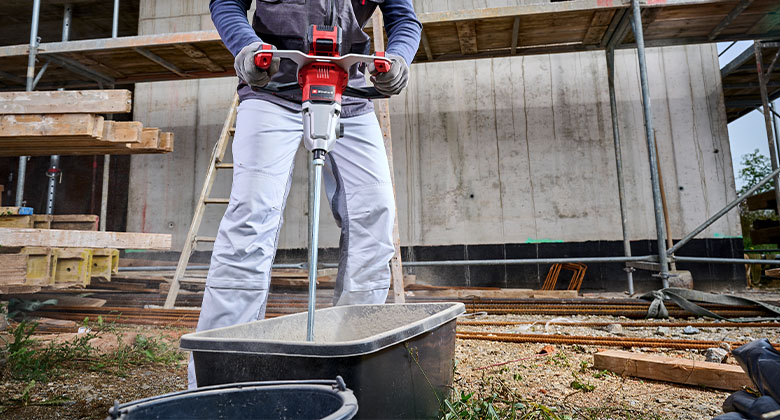 A man using the mortar mixer on a construction site.